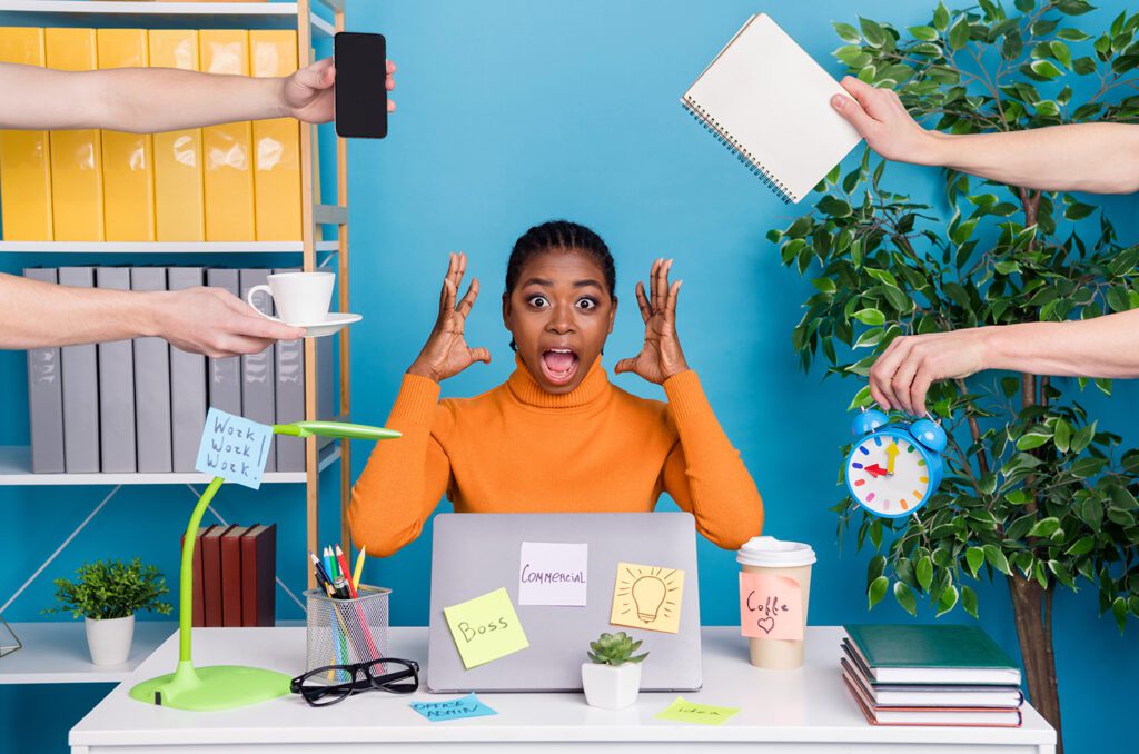 Stressed IT manager dealing with multiple technical tasks and alerts.